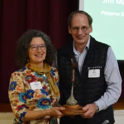 Laura Mattei presents Jim Makuc with the 2023 Steward of the Land Award.